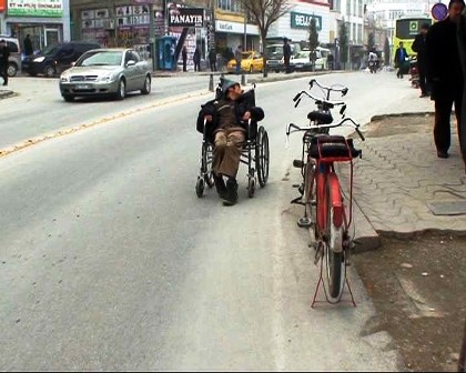 Bozuk tekerlekli arabasıyla ters gidiyor