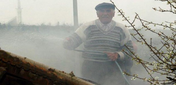 Yanan evini hortumla su sıkarak söndürmeye çalıştı