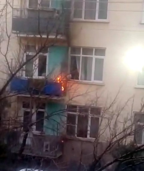 Balkonunda çıkan yangını pencereden su döküp söndürdü