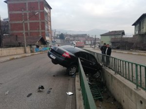 Yoldan çıkan otomobil su kanalında askıda kaldı