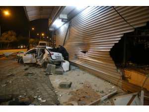Adana'da otomobil direğe ve iş yerine çarptı