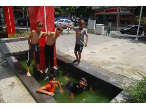 Sıcaktan bunalan çocuklar süs havuzunda serinledi