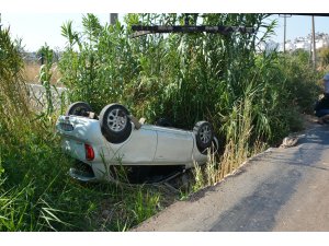 Kanala devrilen otomobilden yara almadan kurtuldular