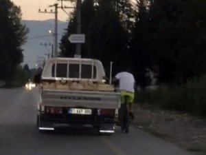 Kamyonete takılan bisikletli görenleri şaşkına çevirdi