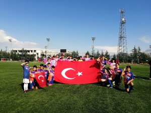 Yeşil sahada, miniklerden Türk Bayraklı asker selamı
