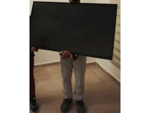 Örtüye sarılı televizyonu taşırken polise yakalandılar