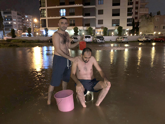 İzmir'de su kesintisine dikkat çekmek için yağmur suyuyla sokakta yıkandılar