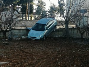 Otomobil bahçe duvarını aşıp askıda kaldı