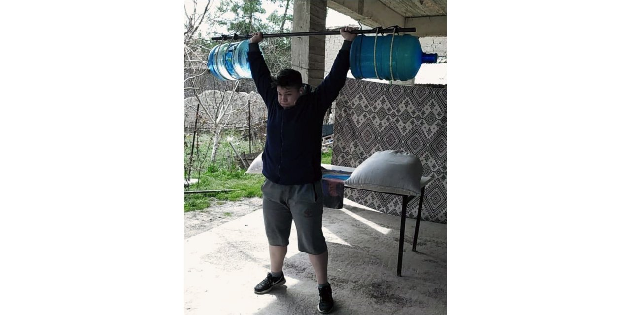 Genç kadın halterci, damacanadan yaptığı halter barlarıyla çalışıyor