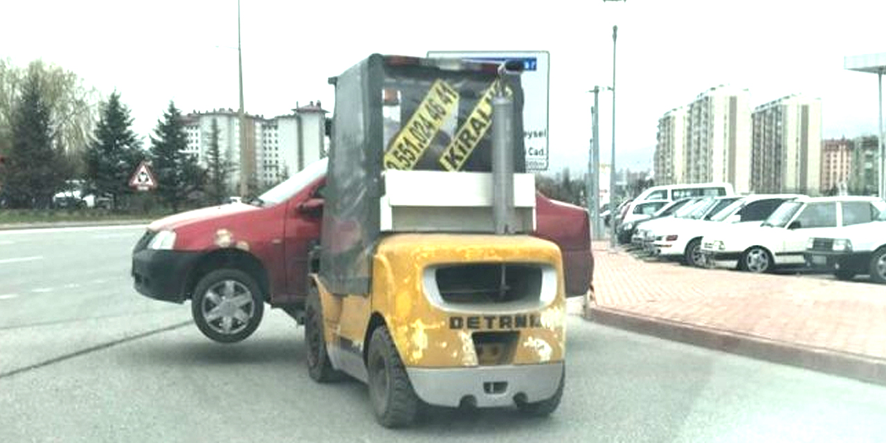 Forklift ile caddede otomobil taşıdı