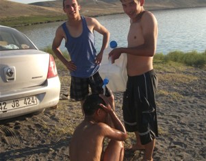 Yüzdükten sonra bidonlarla duş alıyorlar