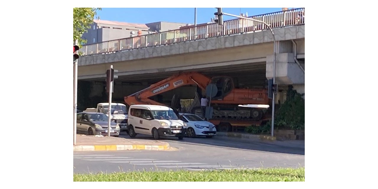 Tırın dorsesinde taşınan iş makinesi köprülü kavşakta üst geçide sıkıştı