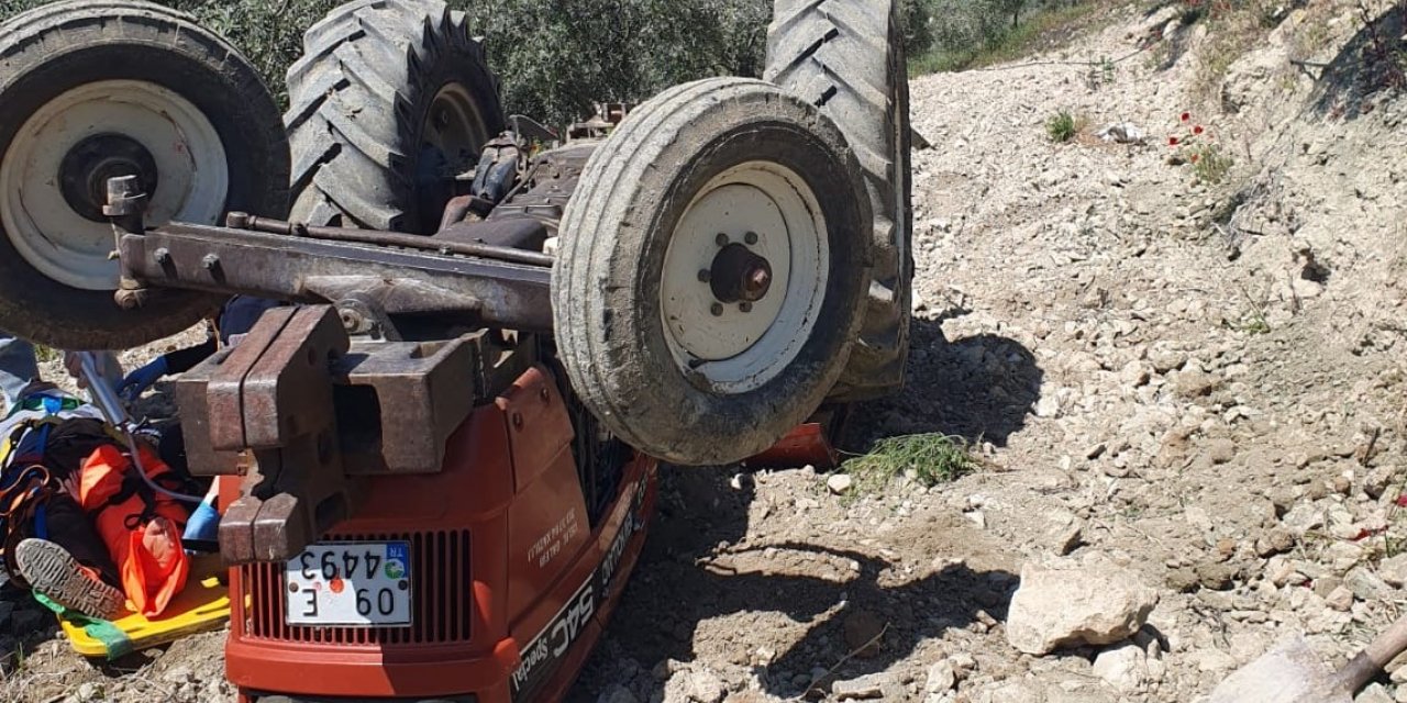Devrilen traktörün altından yardım istedi