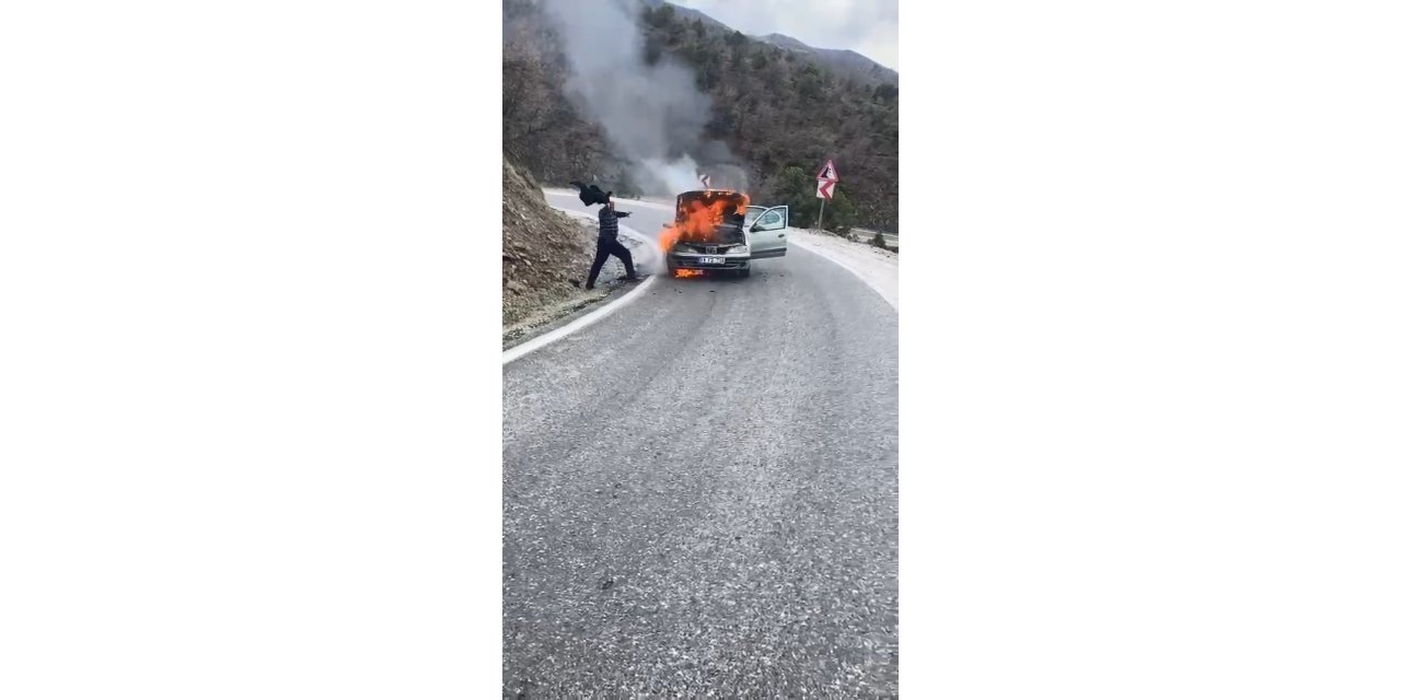 Alev alev yanan otomobili ceketi ile söndürmeye çalıştı, imdadına diğer sürücüler yetişti
