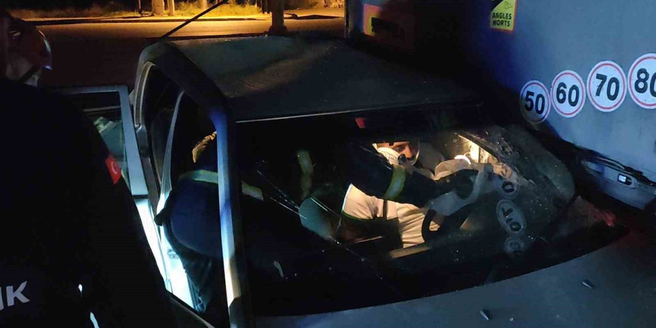 Otomobil park halindeki tırın altına girdi