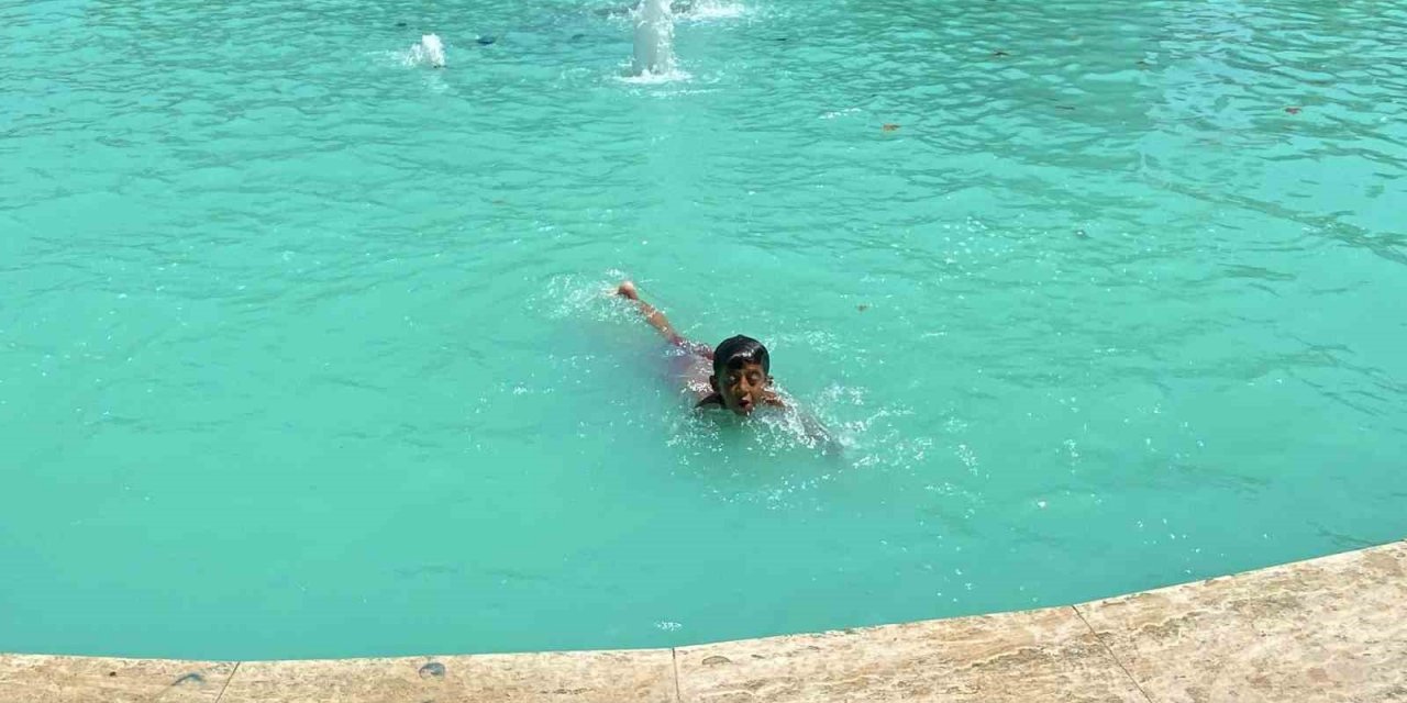 Kavurucu çöl sıcağında vatandaşlar gölgelik alanlara, çocuklar ise süs havuzuna koştu