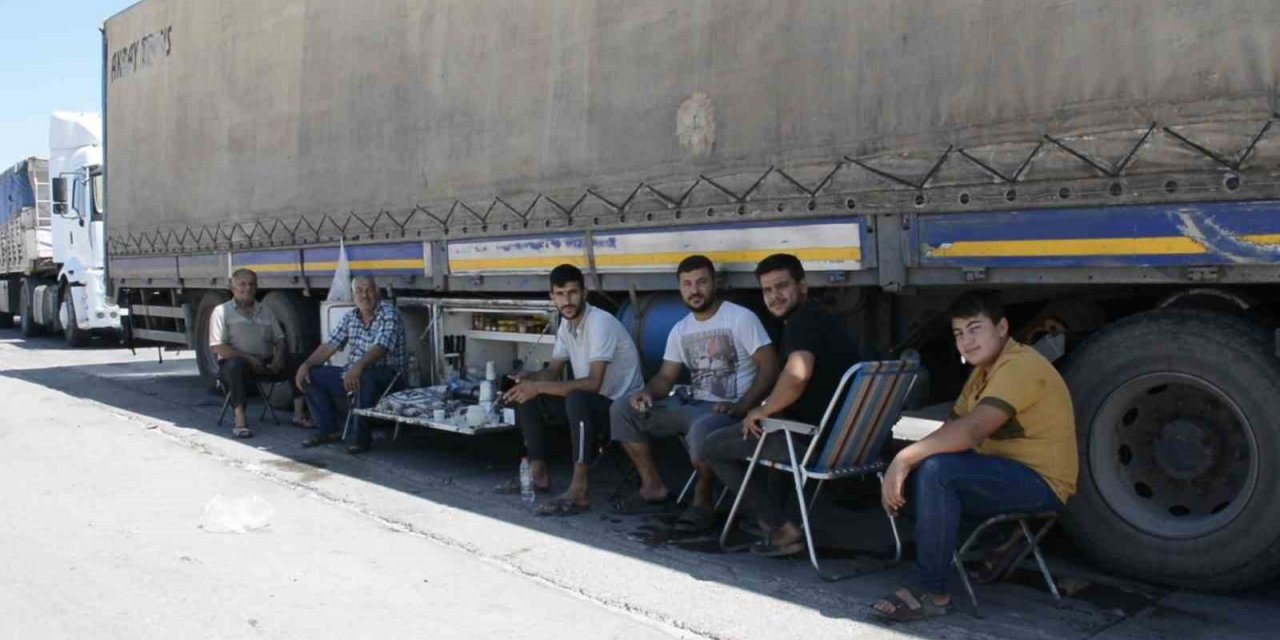 Şırnak’ta tır parkında bekleyen şoförler araçlarının gölgesinde serinliyor