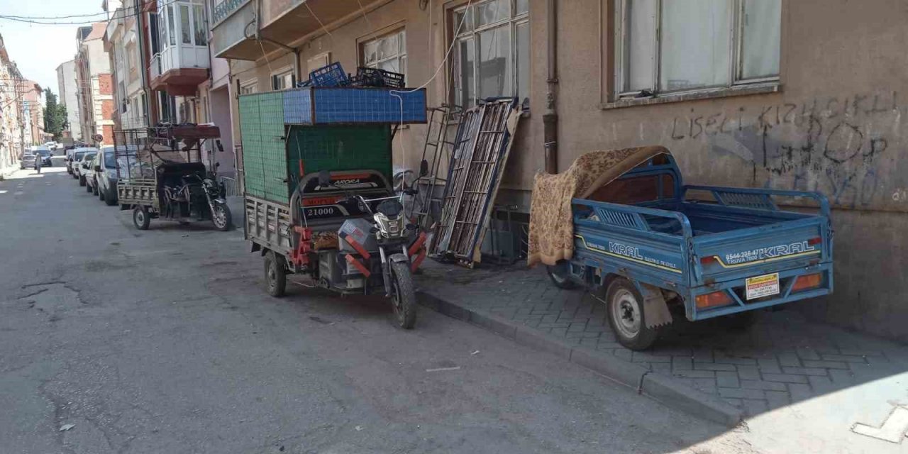 Geri dönüşüm işçilerinin motosikletleri kaldırımdaki engelli rampasını kapatıyor