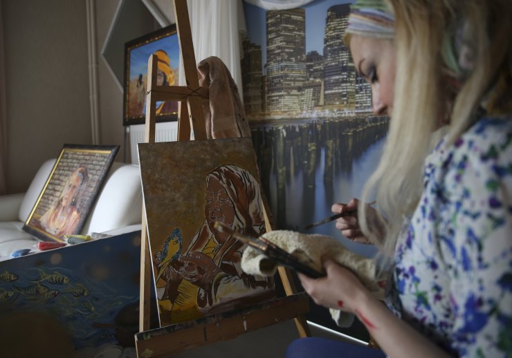 Evindeki atölyesinde yaptığı resimlerle "kadına şiddeti" anlattı