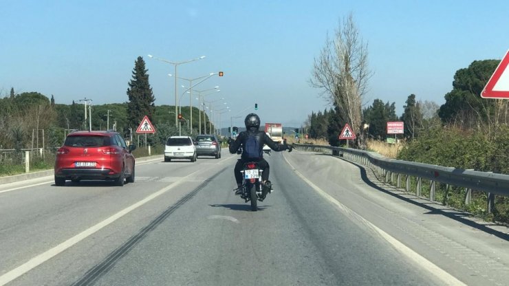 Müzik dinleyen motosikletçiden trafikte tehlikeli hareketler