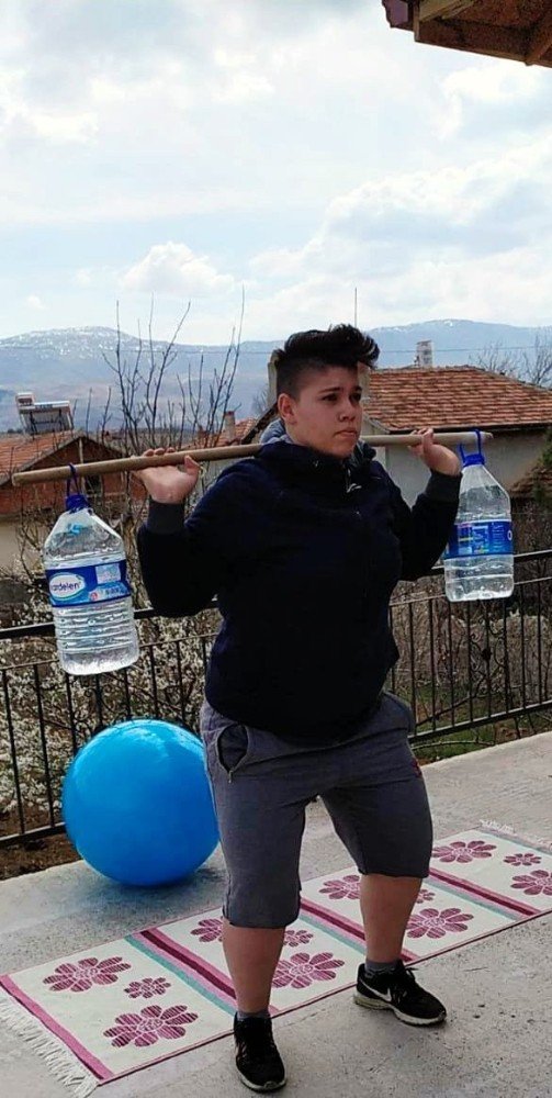 Genç kadın halterci, damacanadan yaptığı halter barlarıyla çalışıyor