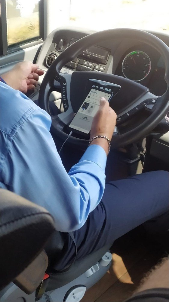 Şehirlerarası otobüs şoförünün bir elinde telefon, bir elinde çekirdek