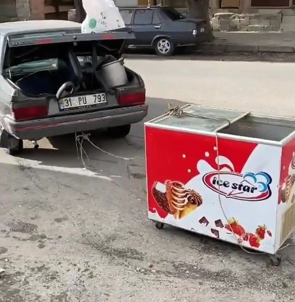 Arabasına bağladığı dondurma dolabını çekmeye çalıştı
