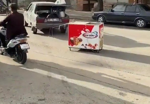 Arabasına bağladığı dondurma dolabını çekmeye çalıştı