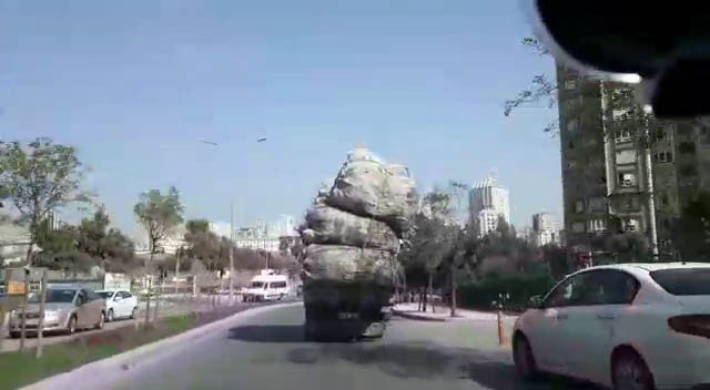Kasasında metrelerce yükseklikteki çuvallarla ilerleyen kamyon kamerada