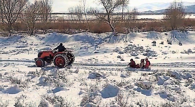 Kar yağışının tadı böyle çıkar! Traktörün arkasına kızak bağlayıp çocukları eğlendirdiler