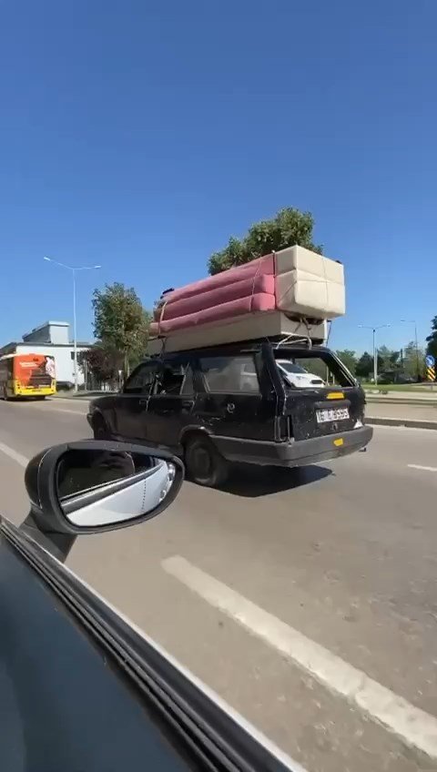 Aynasız otomobilin tavanında koltuk taşıyan sürücü ehliyetsiz çıktı