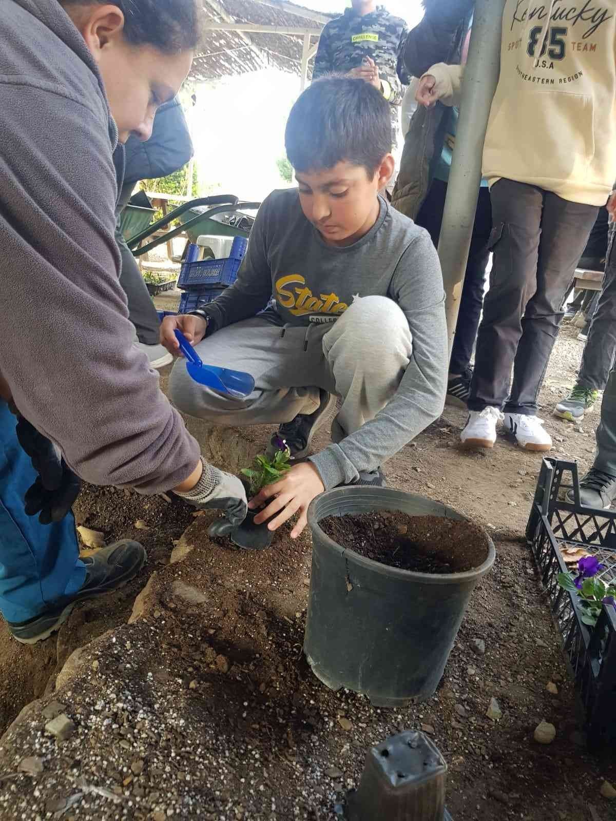 Öğrenciler, belediye serasında çiçekleri toprakla buluşturdu