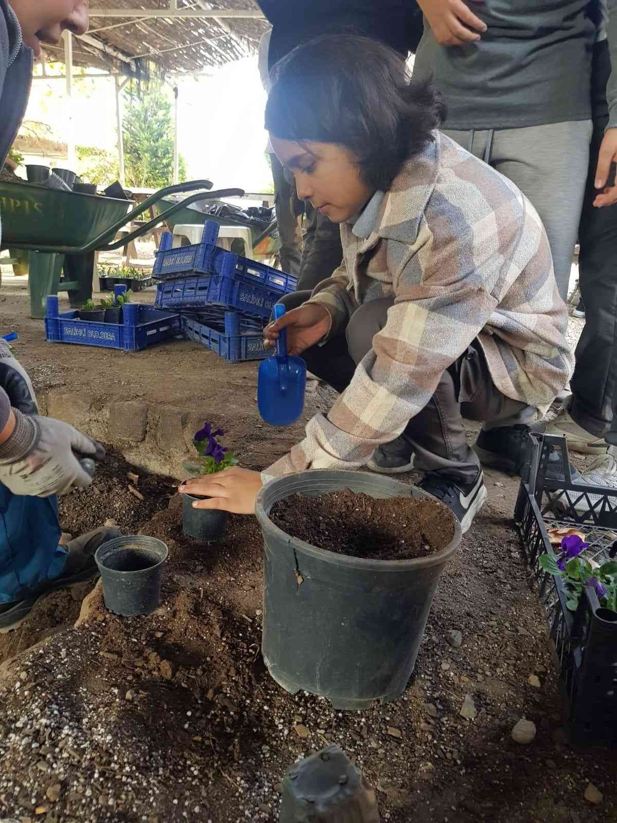 Öğrenciler, belediye serasında çiçekleri toprakla buluşturdu