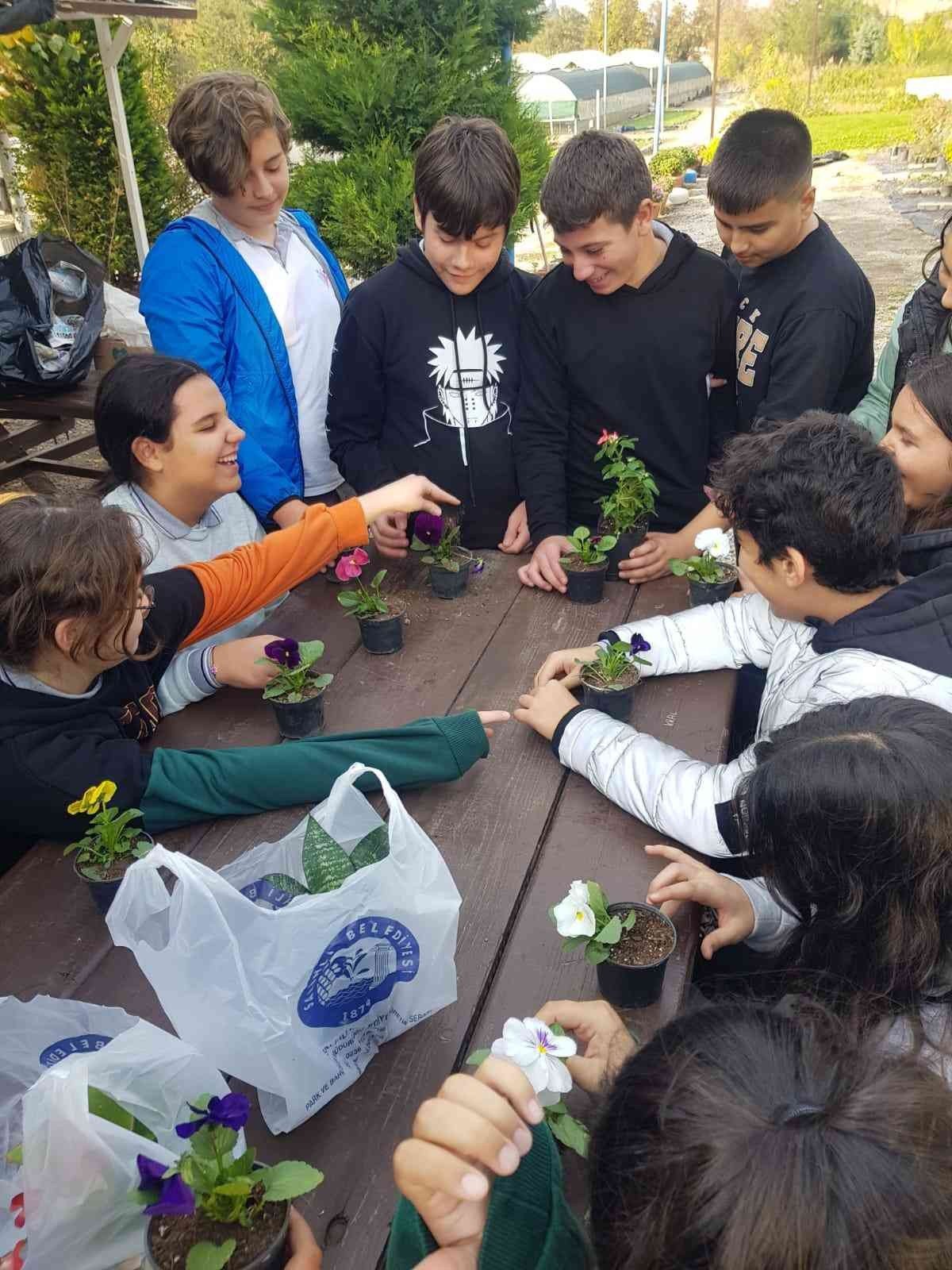 Öğrenciler, belediye serasında çiçekleri toprakla buluşturdu