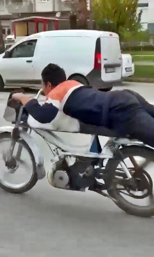 Motosikleti yüzüstü yatarak kullanan gencin görüntüleri tepki çekti
