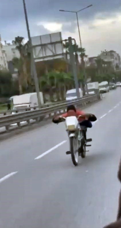 Motosikleti yüzüstü yatarak kullanan gencin görüntüleri tepki çekti