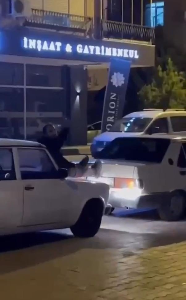 İki otomobilin arasına uzanıp, arızalanan aracı ayaklarıyla itti