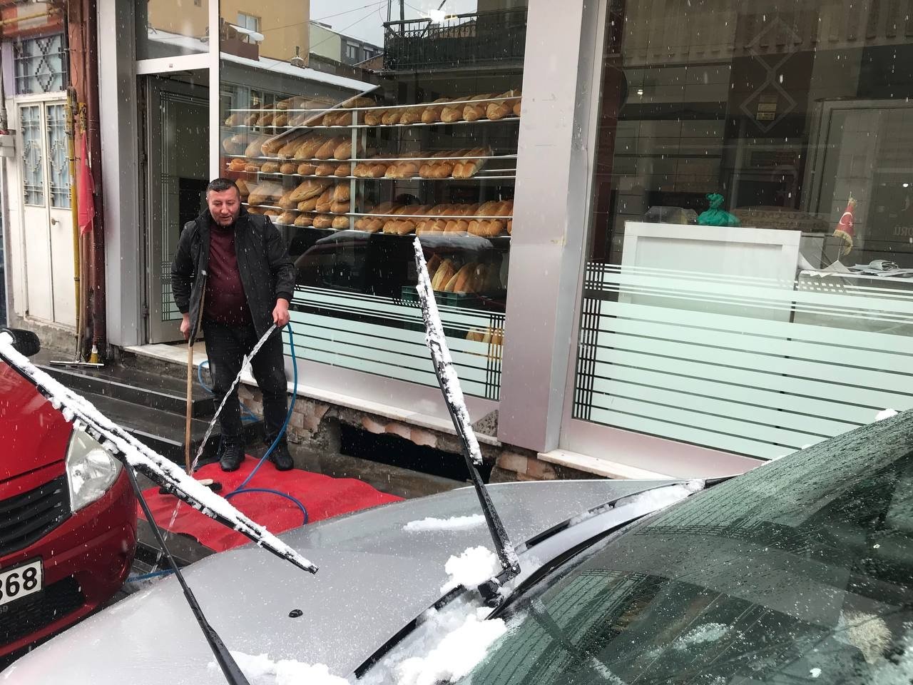 Bayburtlu esnaf kar yağışı altında paspas yıkayarak araç temizliği yaptı