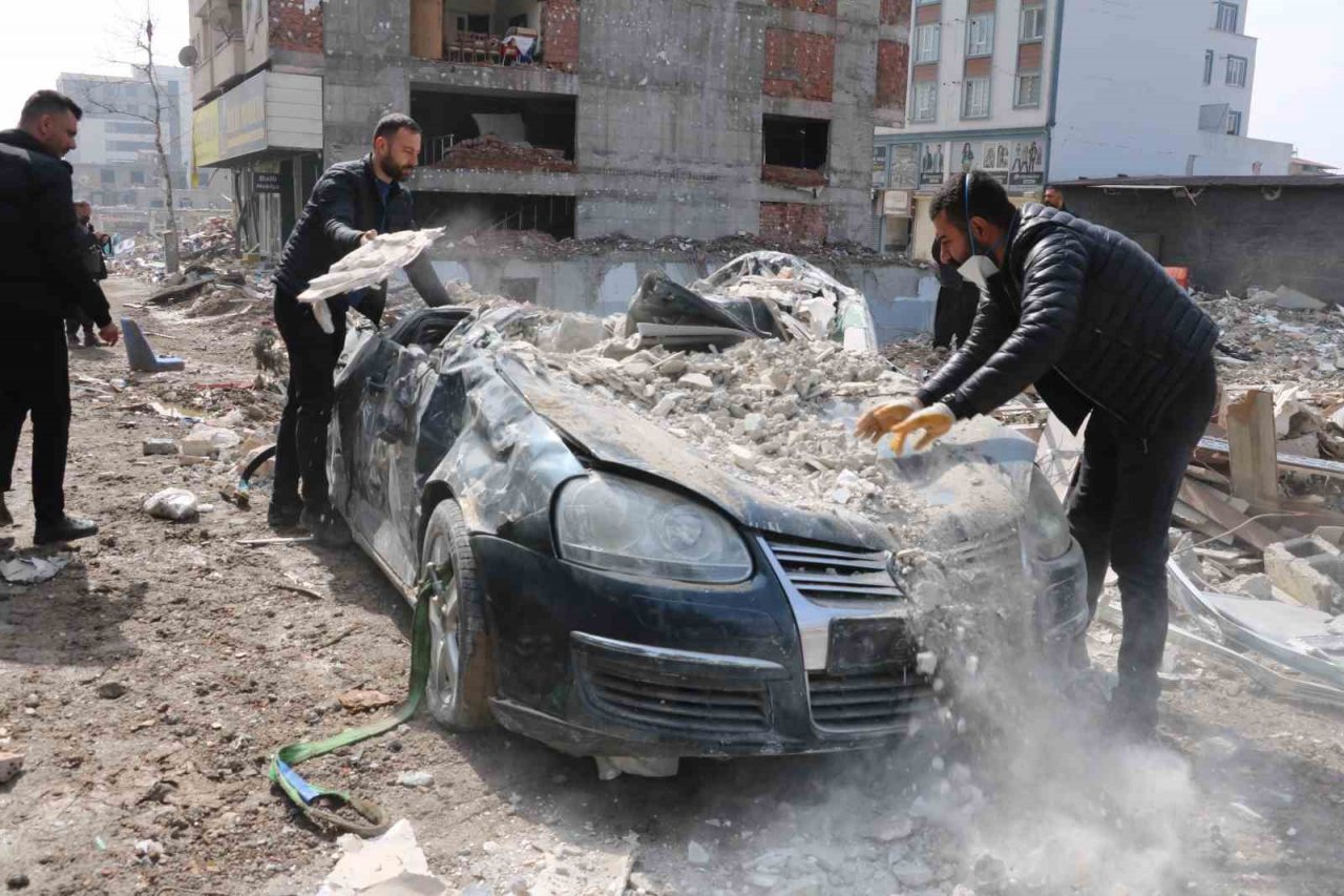 Enkazdan çıkardıkları otomobili elleriyle temizlediler