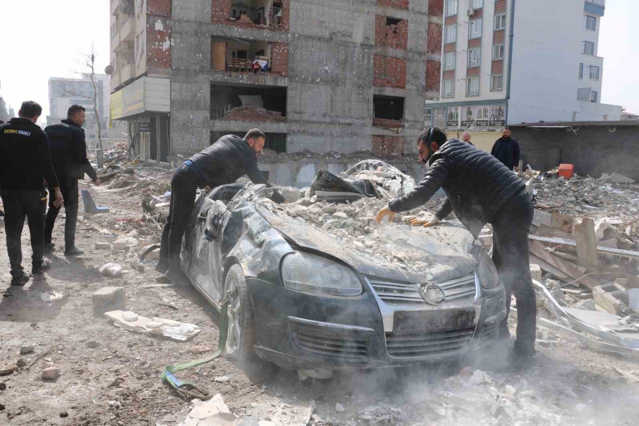 Enkazdan çıkardıkları otomobili elleriyle temizlediler