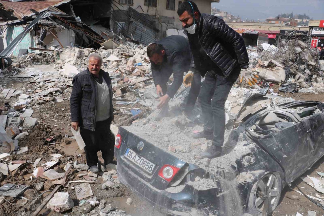 Enkazdan çıkardıkları otomobili elleriyle temizlediler