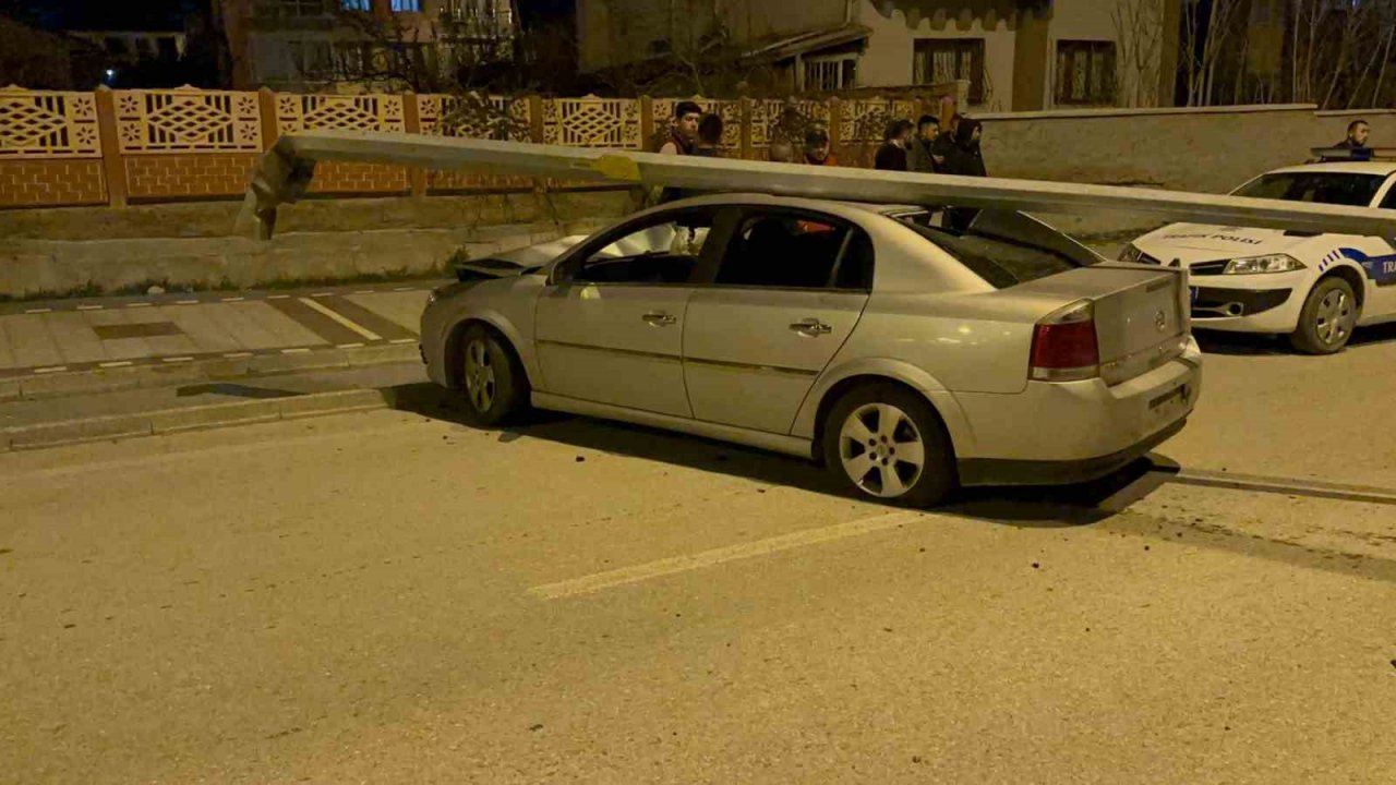 Çarptığı direk otomobilin üzerine devrildi