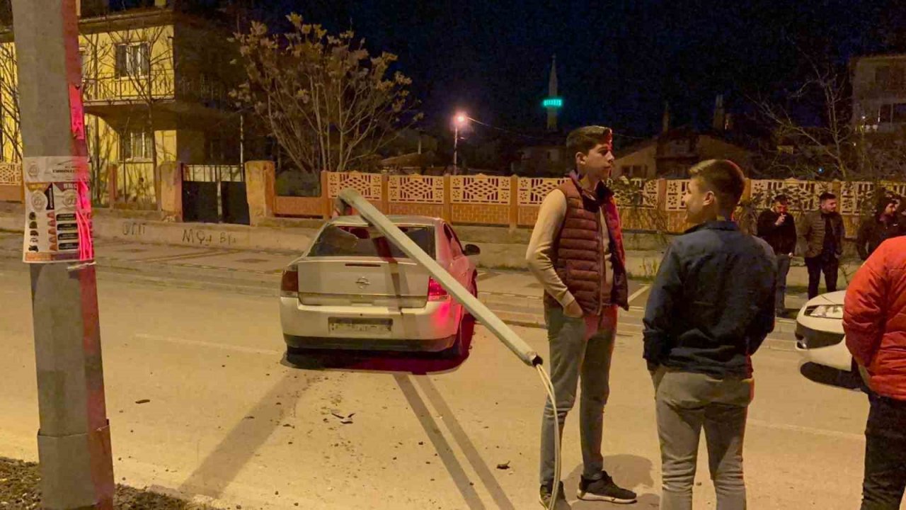 Çarptığı direk otomobilin üzerine devrildi