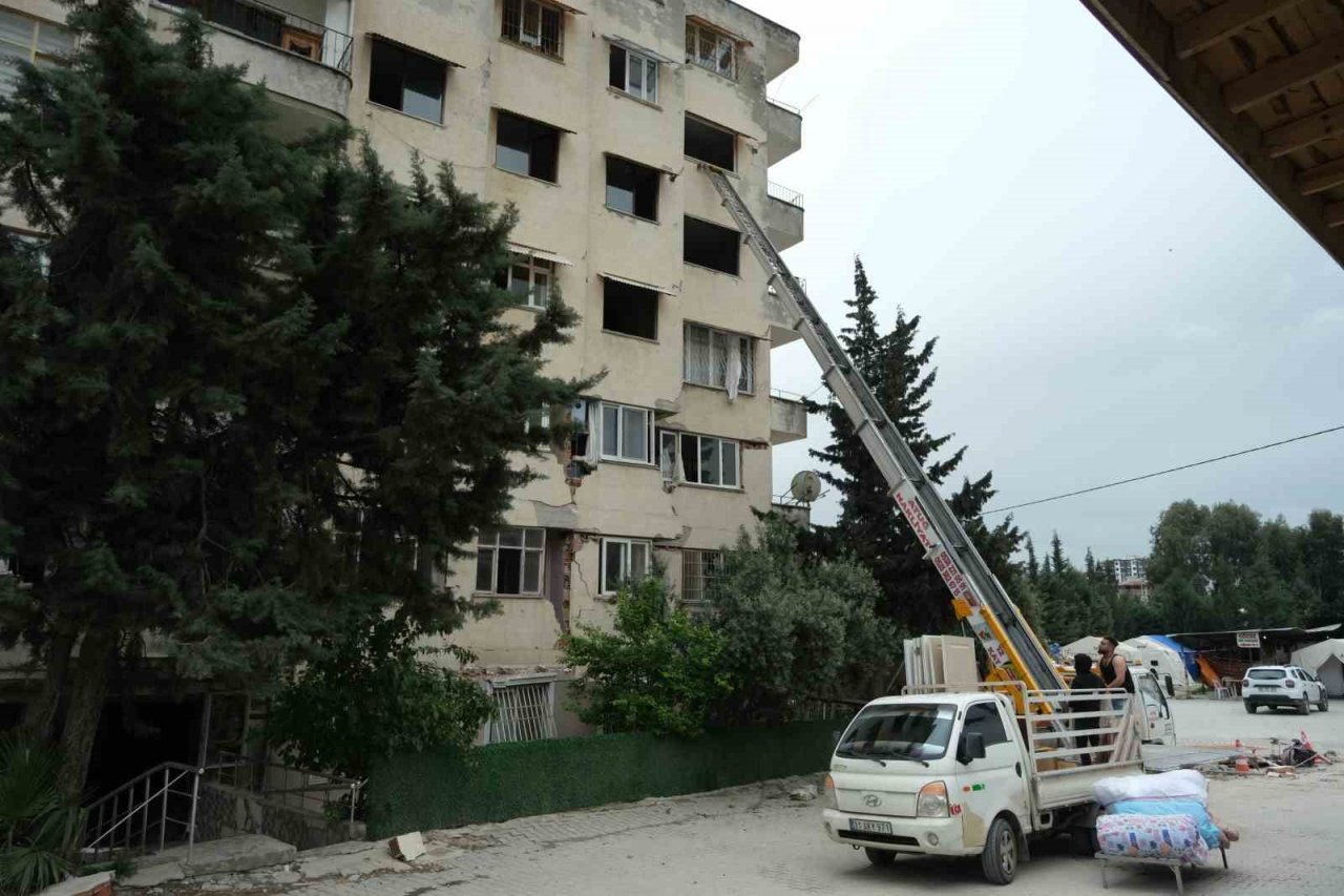 Canlarını riske atıp ağır hasarlı binalardan eşya çıkarıyorlar