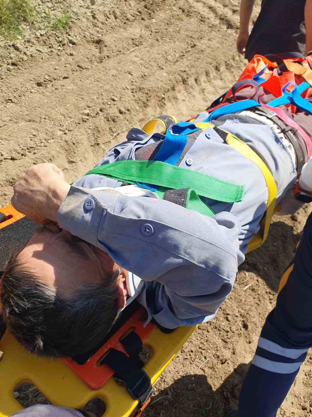 Devrilen traktörün altından yardım istedi