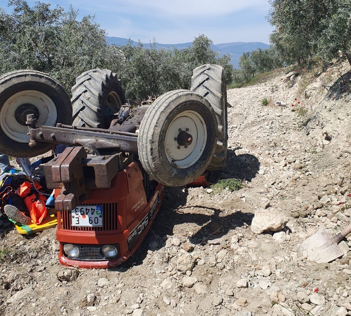 Devrilen traktörün altından yardım istedi