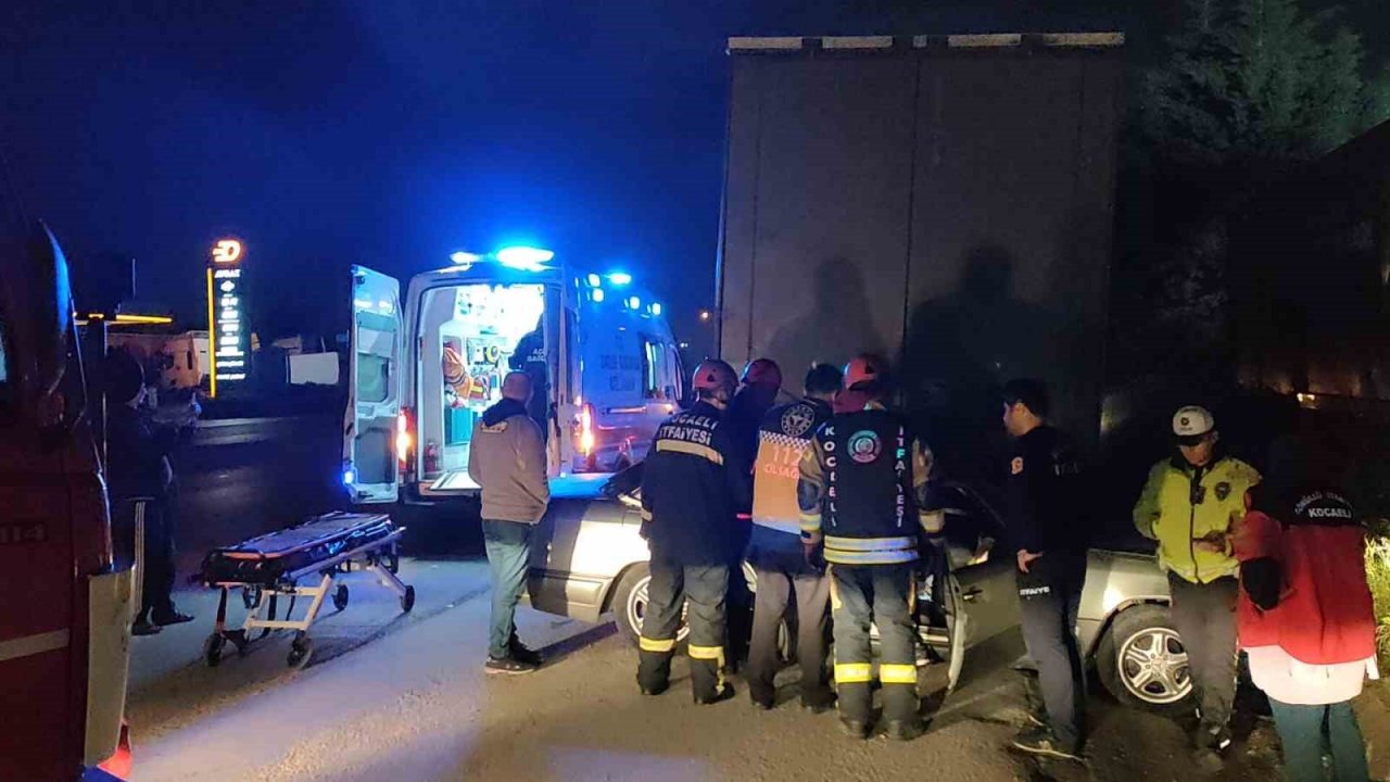 Otomobil park halindeki tırın altına girdi