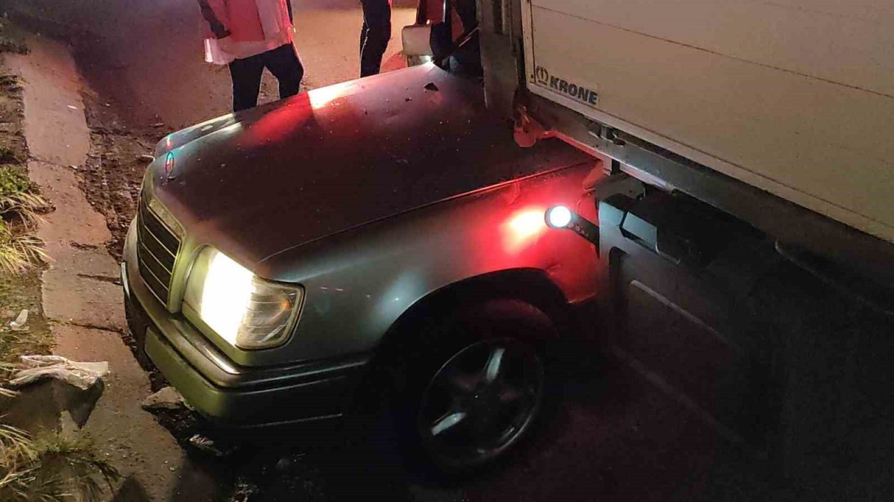 Otomobil park halindeki tırın altına girdi