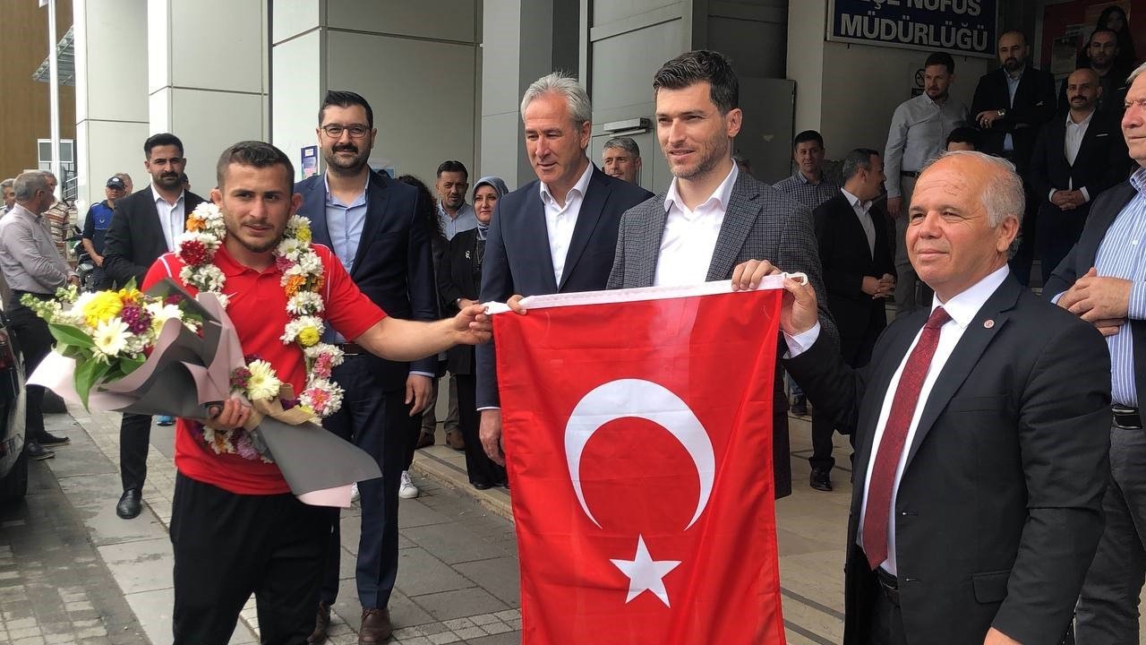 Dünya birincisi sporcu çiçeklerle karşılandı