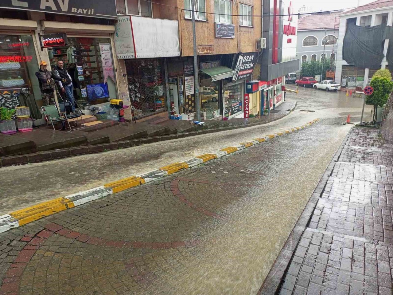 Yolu su bastı, esnaf ise sandalyesini alıp keyif yaptı